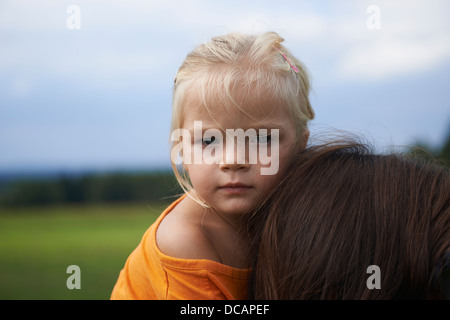 Ritratto di bambino ragazza bionda - figlia ottenendo un piggy back da sua madre nel parco Foto Stock