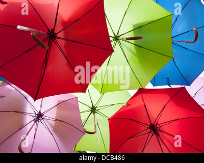 Vivacemente colorato ombrelloni appesi in un display a Londra REGNO UNITO Foto Stock