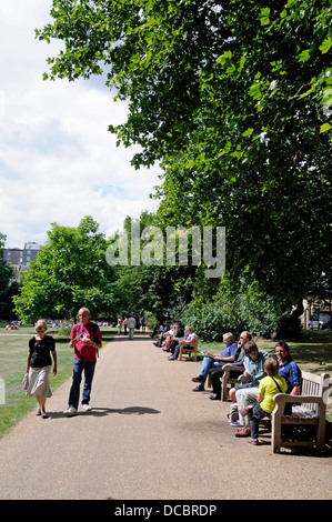 Lincoln' s Inn campi pubblici di Piazza con gente seduta sulle panchine godendo il sole, Londra Inghilterra REGNO UNITO Foto Stock