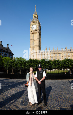 Turista femminile in posa con british Metropolitan Police office custodendo le case del parlamento Londra Inghilterra REGNO UNITO Foto Stock