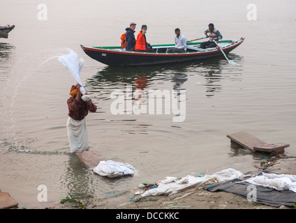 Gli uomini a lavare i panni nel fiume Gange nella parte anteriore dei turisti, Varanasi, India Foto Stock