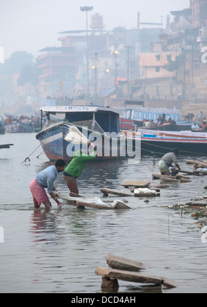 Gli uomini a lavare i panni nel fiume Gange, Varanasi, India Foto Stock