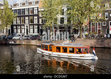 Barca sul canale Keizersgracht ed edifici storici in Olanda, Amsterdam, Paesi Bassi. Foto Stock
