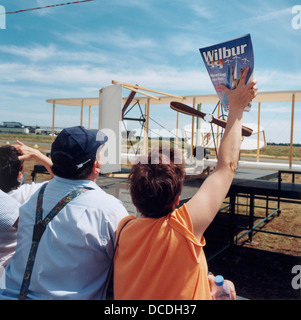 Il francese gli appassionati di aviazione in corrispondenza di un'esibizione aerea a Le Mans in Francia norhtern guarda l'acrobazia overhead e nella parte anteriore di una replica in scala del Flyer, il primo aereo alimentato dalla American fratelli Wright. Foto Stock