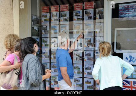 Famiglia guardando agente immobiliare per la finestra dei prezzi degli immobili in Puy L Eveque nel sacco Regione o dipartimento di Francia Foto Stock