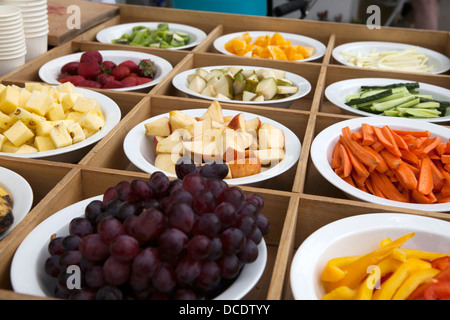Frutta e verdura fette in verde i colori rosso e giallo su piastre nella casella sul display Foto Stock