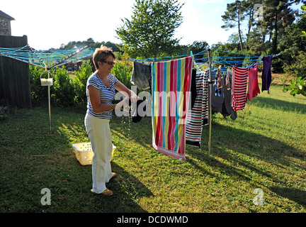 Donna appendere fuori il lavaggio a secco alla vacanza gite nel sacco Regione o dipartimento del sud ovest di midi-Pyrenees area della Francia Foto Stock