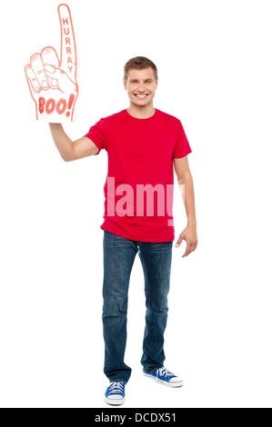 Casual guy mostrando grande appuntito di boo hurray mano giocattolo. A piena lunghezza ritratto Foto Stock