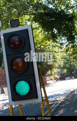 Semafori provvisori a lavori stradali che mostra una luce verde. Foto Stock