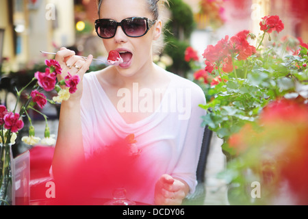 Felice brunette donna mangiare fragole dolci Foto Stock