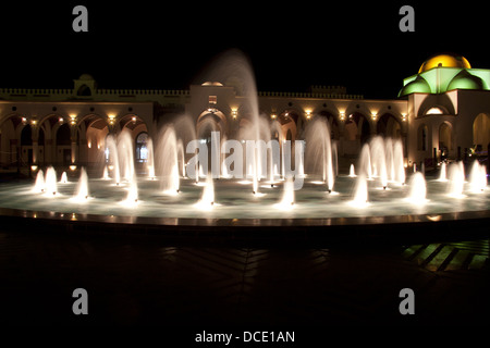 Dancing colorato fontana nella notte buia Foto Stock