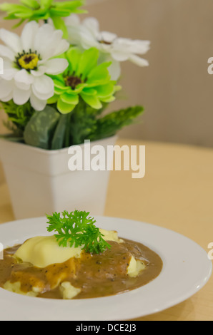 Purea di patate con salsa gravy versata sopra nella ciotola bianco Foto Stock