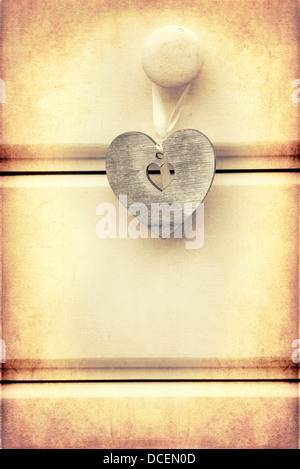 Macro croce retrò elaborati per effetto immagine del cuore di legno su sfondo di legno Foto Stock