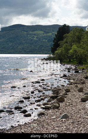 Guardando attraverso la spiaggia di ciottoli a Dores di Tor punto sulle rive di Loch Ness vicino a Inverness Scozia Scotland Foto Stock