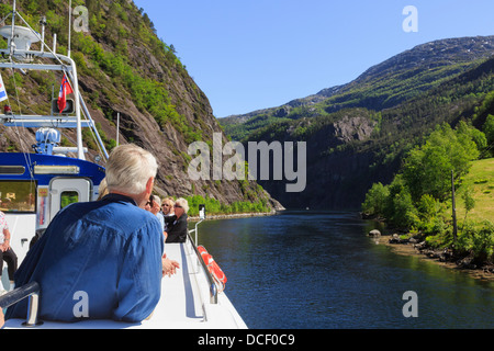 I turisti sul ponte di una crociera panoramica in barca a vela lungo stretti Mostraumen Mofjorden al fiordo. Modalen Hordaland Norvegia Foto Stock