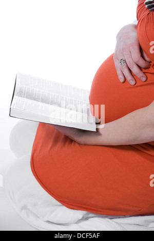 Donna Incinta della lettura della Bibbia Foto Stock