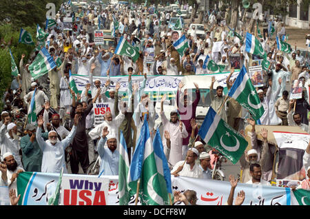 I sostenitori e gli attivisti di Jamat-e-Islami (JI) stanno dimostrando per esprimere la loro solidarietà con il popolo d'Egitto e i sostenitori di morsi, a M.A Jinnah Road a Karachi il Venerdì, 16 agosto 2013. I dimostranti trasportare carte gioco scritto slogan in favore morsi e anti esercito egiziano, manifestanti masterizzare noi bandiera durante la protesta e condanna fermamente la brutale repressione dell esercito contro le persone innocenti di Egitto, compresi donne e bambini e ha detto che il generale dell esercito Al-Saysee sarà sicuramente pagare per questo brutale atto. Foto Stock