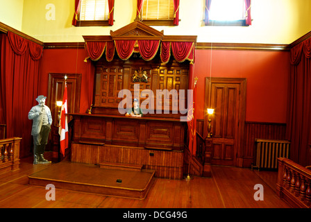 Turista femminile sitting Banco giudice ex assise courtroom heritage courthouse building Bastion Square Victoria BC Foto Stock