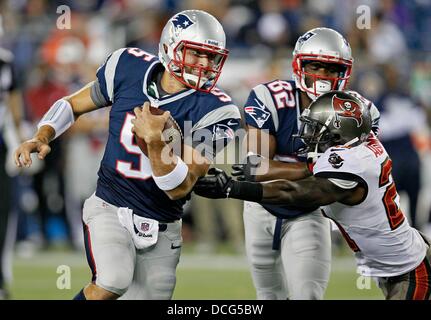 Foxborough, Florida, Stati Uniti d'America. 16 Ago, 2013. New England Patriots quarterback TIM TEBOW (sinistra) codifica per evitare di Tampa Bay Buccaneers cornerback MICHAEL ADAMS durante il quarto trimestre come il Tampa Bay Buccaneers play New England Patriots durante una partita di preseason a Gillette Stadium. Credito: Daniel Wallace/Tampa Bay volte/ZUMAPRESS.com/Alamy Live News Foto Stock