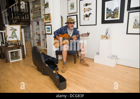 Local blues cantante chitarrista signor H gioca a vuoto e sede presso la Galleria ardente durante Brecon Jazz Festival 2013 Foto Stock