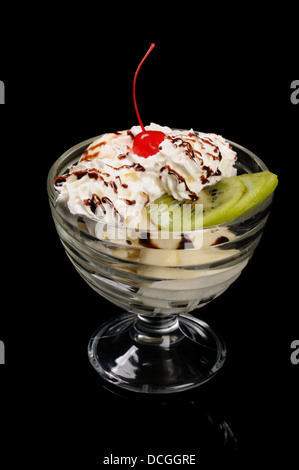 Gelato alla crema con le fette di kiwi su sfondo nero Foto Stock