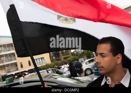 Londra, Regno Unito. 17 Ago, 2013. Un egiziano dell'uomo ctaches bandiera la brezza come oltre 100 British egiziani di tenere un drive-by protesta per le strade di Londra contro il colpo di stato militare e i successivi atti di violenza in Egitto Credito: Paolo Davey/Alamy Live News Foto Stock