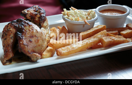 Mezzo pollo arrosto con patatine, coleslaw e piri-piri sauce servita in un pub in St Neots, Cambridgeshire, Inghilterra Foto Stock