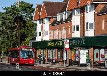 Marchi e & Spencer (M&S) store / shop, con bus locale e due persone all'esterno, su un tranquillo villaggio di Banstead High Street, nel Surrey, Inghilterra, Regno Unito. Foto Stock