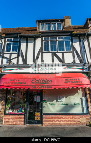 Delicatessen con appartamenti sopra, sul villaggio di Banstead High Street (viveri), su una tranquilla domenica mattina nel Surrey, Inghilterra, Regno Unito. Foto Stock