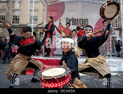 Edimburgo, Scozia il 18 agosto 2013, i membri del cast dal Ryukyu-Contemporary eseguire una parte del loro spettacolo su Edinburgh Fringe stadio a Royal Mile include la musica contemporanea con Ryukyu tradizionale danza e arti marziali. Nave di Ryukyu è un collettivo di cantanti e ballerini di Okinawa, in Giappone Foto Stock