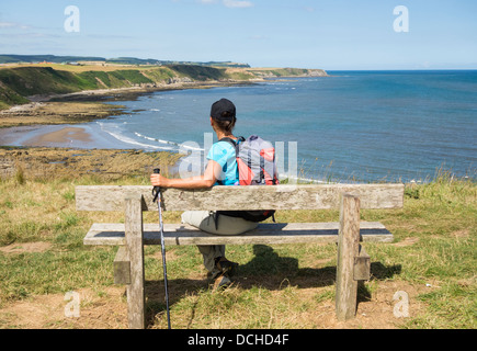 Escursionista femmina sul modo di Cleveland National Trail tra Scarborough e Robin Hood's Bay a nord della Costa dello Yorkshire, Inghilterra. Foto Stock