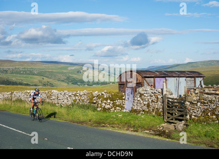 Ciclista sulla salita oltre Buttertubs passano nel Yorkshire Dales National Park. Yorkshire, Inghilterra, Regno Unito Foto Stock
