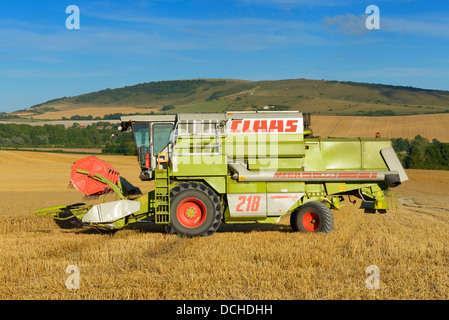 Un CLAAS mietitrebbia lavora in un campo di grano sul South Downs, East Sussex, Regno Unito Foto Stock