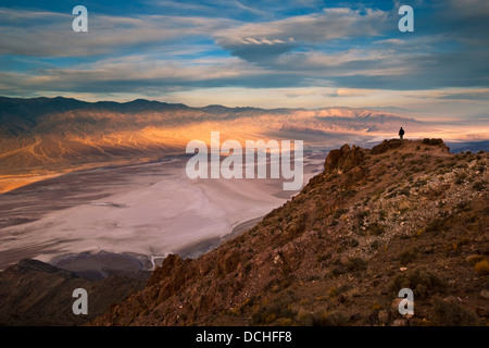 Turista che si affaccia sulle montagne Panamint oltre il bacino Badwater, da Dantes Vista Parco Nazionale della Valle della Morte, California Foto Stock