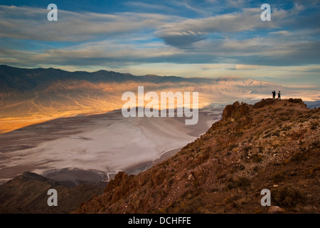 I turisti che si affaccia sulle montagne Panamint oltre il bacino Badwater, da Dantes Vista Parco Nazionale della Valle della Morte, California Foto Stock