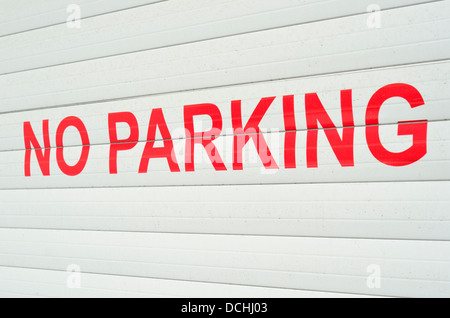Nessun segno di parcheggio in rosso grassetto su un bianco porta di garage Foto Stock