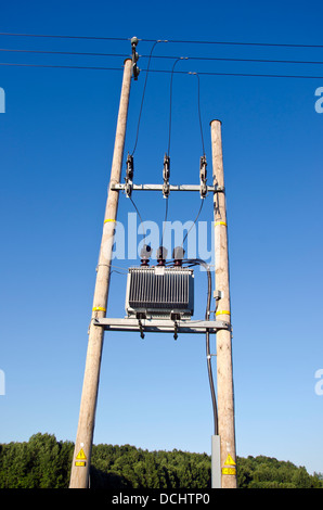 Utility di legno Pole con linee di alimentazione e trasformatore su sfondo cielo Foto Stock