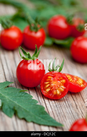 Pomodori ciliegia sulla superficie di legno Foto Stock