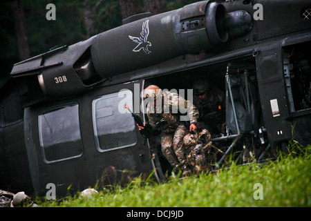 Stati Uniti Air Force Airman 1. Classe Josh Darins e Staff Sgt. Kane Lawlor uscire un U.S. Esercito UH-60 Black Hawk elicottero dal New Jersey Esercito Nazionale della Guardia Assalto 150 Battaglione elicottero durante un inserimento aria esercizio a Fort Pickett, Virginia, il Ago Foto Stock