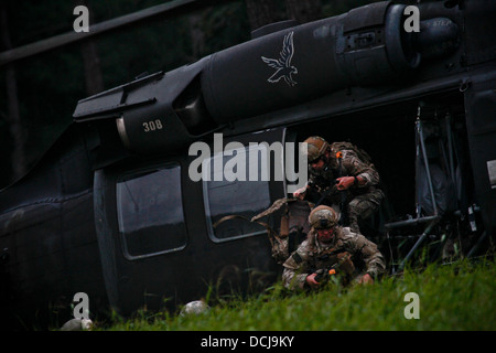 Stati Uniti Air Force Airman 1. Classe Josh Darins e Staff Sgt. Kane Lawlor uscire un U.S. Esercito UH-60 Black Hawk elicottero dal New Jersey Esercito Nazionale della Guardia Assalto 150 Battaglione elicottero durante un inserimento aria esercizio a Fort Pickett, Virginia, il Ago Foto Stock