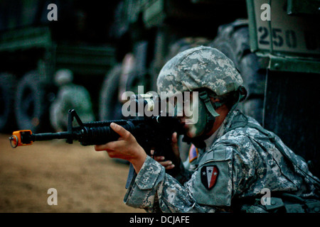 Stati Uniti Army Spc. Nancy Reid dal New Jersey esercito nazionale della guardia 250ª Brigata Battaglione di supporto, cinquantesimo della brigata di fanteria combattere la squadra, esegue la scansione della zona per le minacce mentre fornisce la sicurezza per un convoglio durante una formazione sul campo esercizio a Fort Pickett, Va. Foto Stock