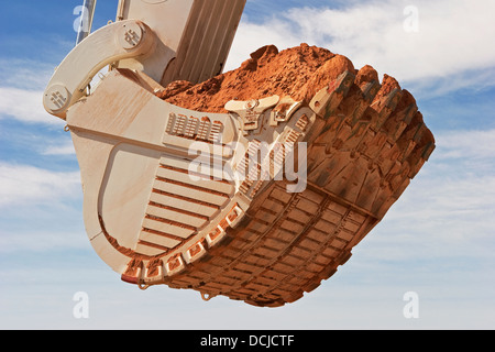 Fossa aperta miniere d'oro in Mauritania. Chiusura del gigante di benna di un escavatore che trasportano minerale. Africa occidentale Foto Stock