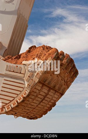 Fossa aperta miniere d'oro in Mauritania. Chiusura del gigante di benna di un escavatore che trasportano minerale. Africa occidentale Foto Stock