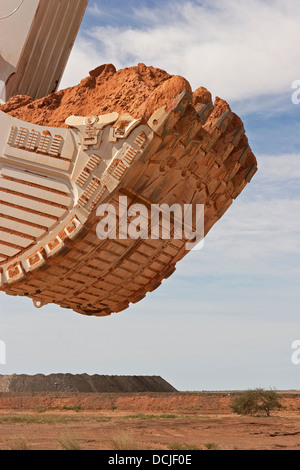 Fossa aperta miniere d'oro in Mauritania. Chiusura del gigante di benna di un escavatore che trasportano minerale. Africa occidentale Foto Stock