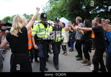 Balcombe, West Sussex, Regno Unito. 19 Ago, 2013. La polizia a portare via uno dei anti fracking manifestanti che avevano bloccato se stessi insieme al di fuori del entarance al sito Cuadrilla . La polizia si scontrarono con anti fracking manifestanti fuori la Cuadrilla sito di perforazione in Balcombe West Sussex oggi fotografia scattata da Simon Dack/Alamy Live News Foto Stock