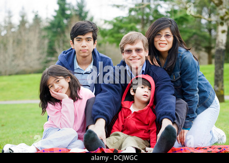 Felice famiglia interraziale godendo di una giornata al parco Foto Stock