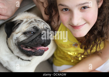 Ragazza con un simpatico cane mops Foto Stock