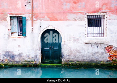 Sbiadita edificio veneziano su un piccolo canale a Venezia, Italia Foto Stock