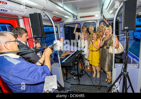 Amburgo, Germania. 19 Ago, 2013. Attori musicali eseguire parti del nuovo musical durante una data di stampa per il nuovo musical 'Linea S1' in un S-Bahn ad Amburgo, Germania, 19 agosto 2013. Il musical di Amburgo si premiere a St. Pauli Theatre il 08 settembre 2013. Foto: Georg Wendt/dpa/Alamy Live News Foto Stock