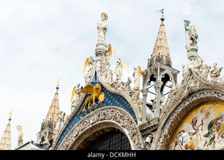 Dettaglio della parte superiore della facciata della Basilica di San Marco, Venezia, con golden leone alato di San Marco e dei mosaici Foto Stock